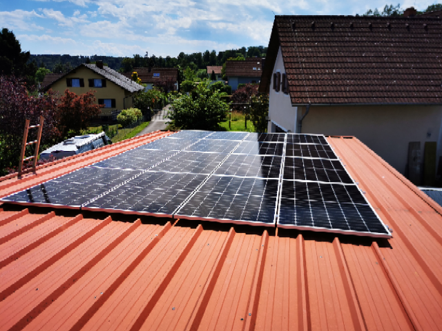 Ein Team von Fachleuten installiert eine PV-Anlage auf einem Wohnhaus