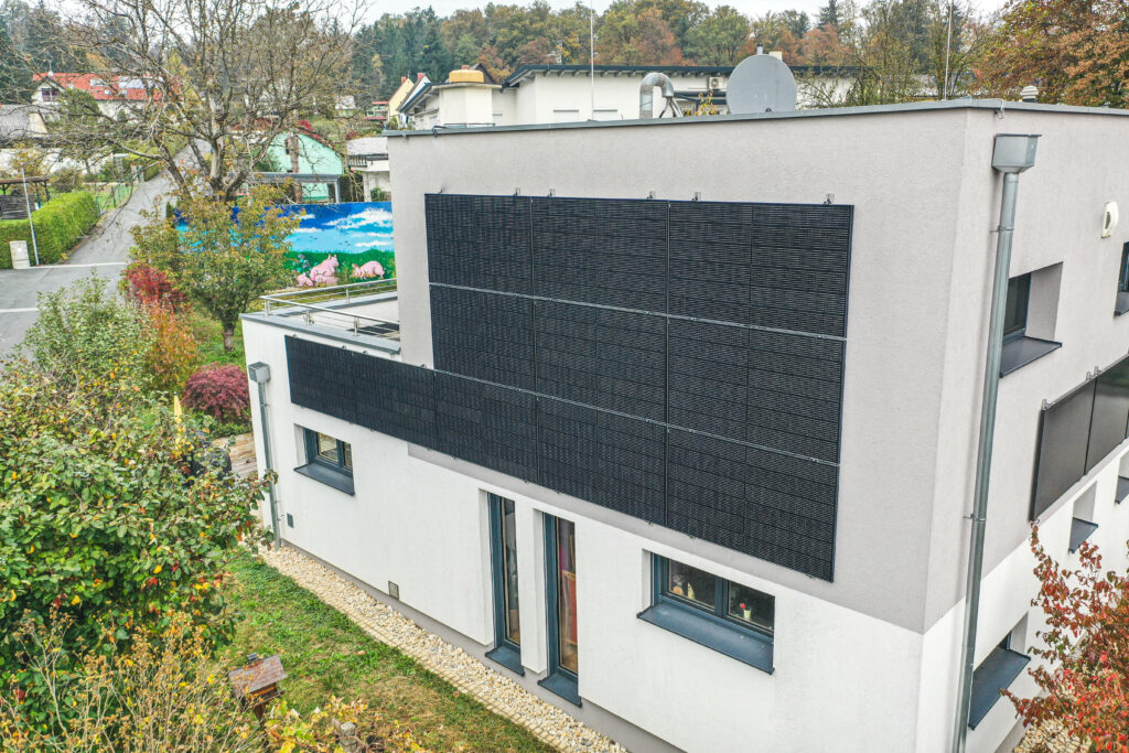 Ein Montageexperte befestigt Solarmodule auf einem Lagergebäude.